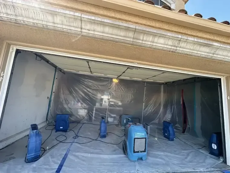 Plastic containment and drying equipment arranged inside a garage with its door open