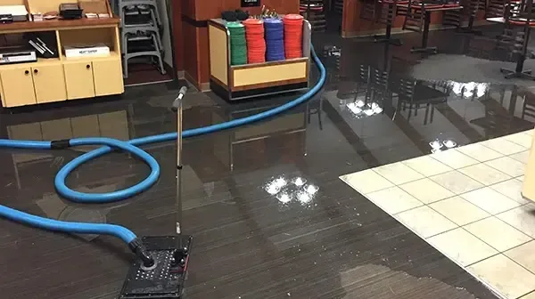 Extraction hoses laid across a flooded school cafeteria