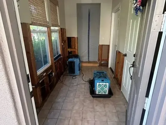 Drying equipment along a tiled hallway with lower wall sections removed