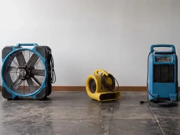 Three drying machines arranged against a plain interior wall